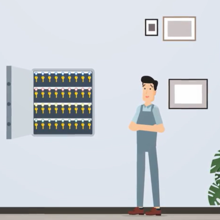 Un homme en salopette bleu devant une armoire à clés.