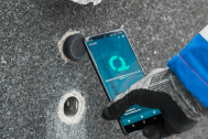 Un téléphone portable avec une animation de chargement, posé près d'un trou.