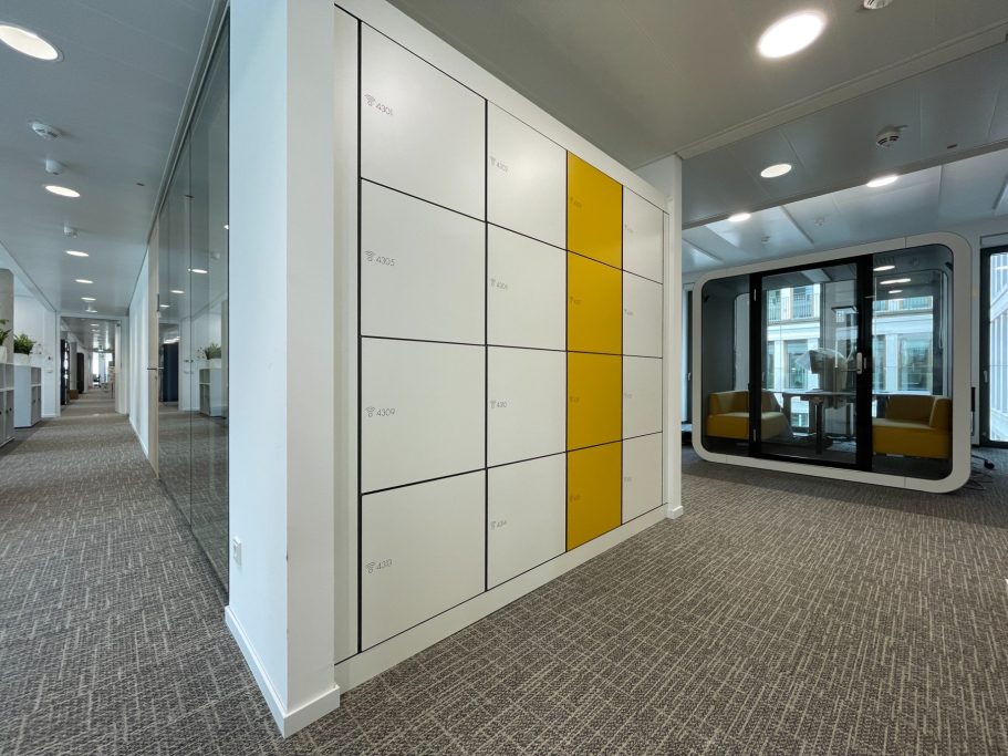 Armoires à casiers en HPL sur mesure avec serrure RFID Casier de rangement blanc avec une porte jaune dans un bureau moderne.